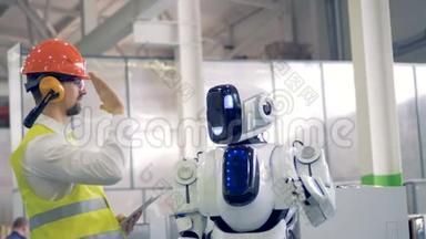 人类工厂的工人和一个机器人在工厂设施里给对方一个击掌。